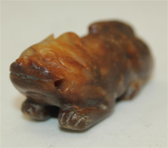 A Chinese celadon and brown jade figure of a recumbent lion-dog, Song dynasty or later, 5.7cm